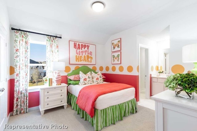 carpeted bedroom featuring connected bathroom and lofted ceiling