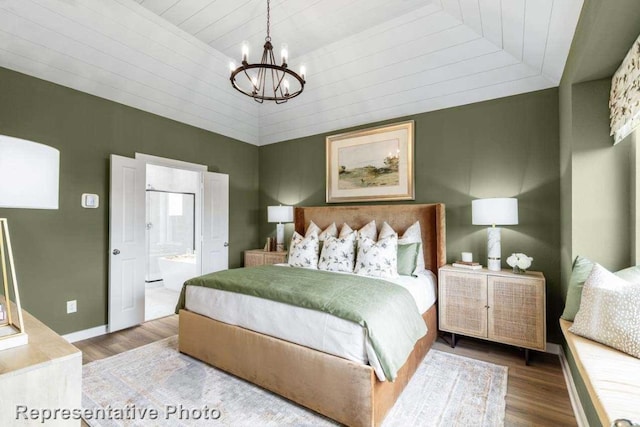 bedroom featuring ensuite bathroom, wooden ceiling, a notable chandelier, hardwood / wood-style floors, and lofted ceiling