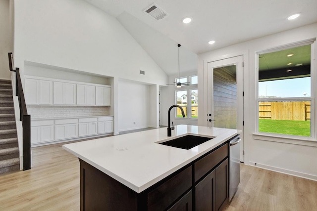 596 Biscayne Bay Bnd, Kyle, TX 78640 - kitchen featuring light wood finished floors, light countertops, dark brown cabinets, visible vents, and a sink