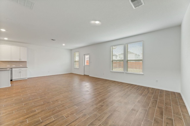 unfurnished living room featuring recessed lighting, visible vents, baseboards, and light wood finished floors