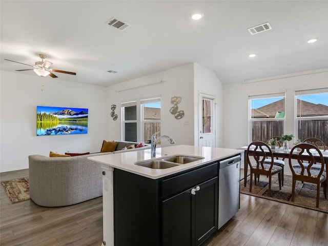 kitchen with ceiling fan, a kitchen island with sink, sink, dishwasher, and dark hardwood / wood-style floors