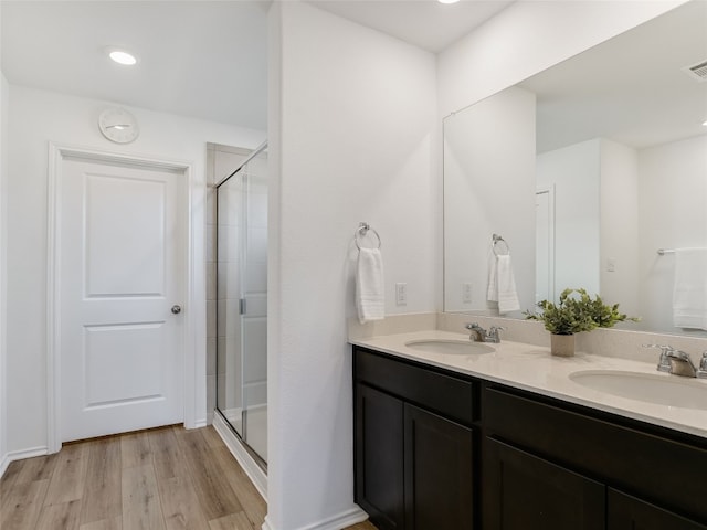 bathroom featuring vanity, an enclosed shower, and hardwood / wood-style flooring