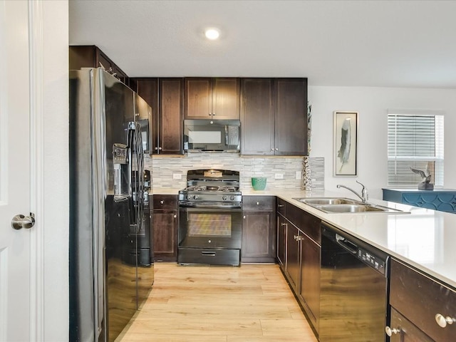 40 Trinity Cir, Lockhart, TX 78644 - kitchen with black appliances, a sink, light countertops, light wood finished floors, and tasteful backsplash