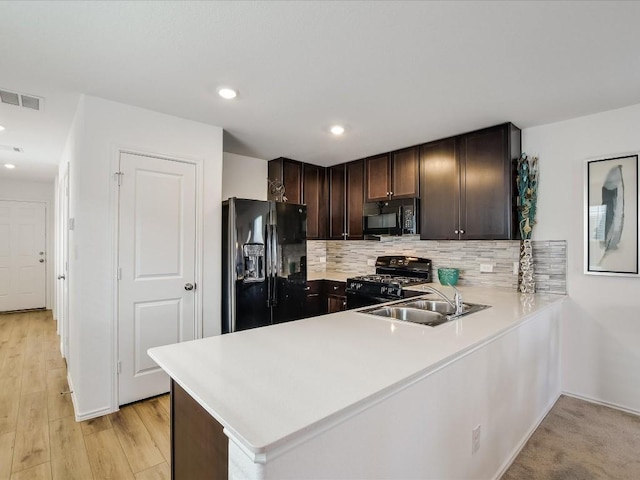 40 Trinity Cir, Lockhart, TX 78644 - kitchen with black appliances, dark brown cabinetry, light countertops, backsplash, and a sink