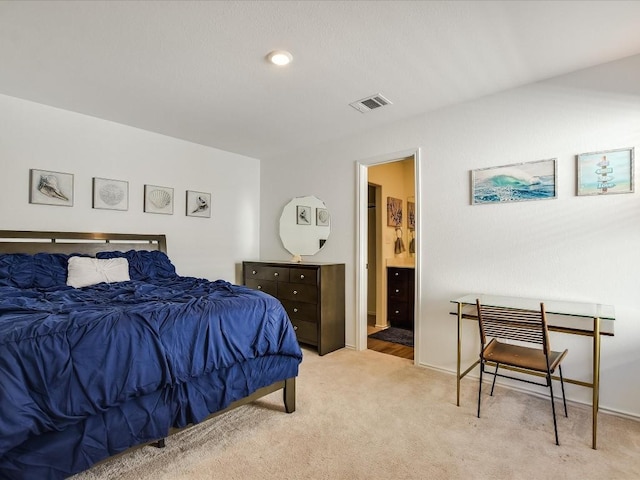 carpeted bedroom featuring ensuite bathroom