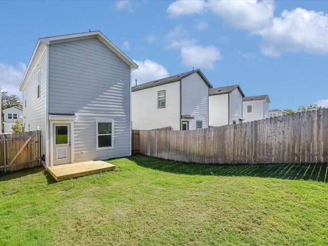 rear view of property featuring a lawn and a wooden deck