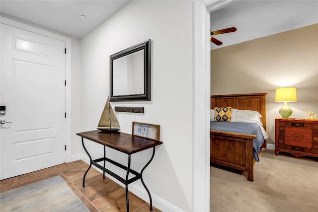 foyer entrance with light carpet and ceiling fan