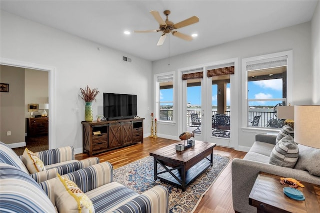 living room featuring ceiling fan, hardwood / wood-style floors, and a healthy amount of sunlight