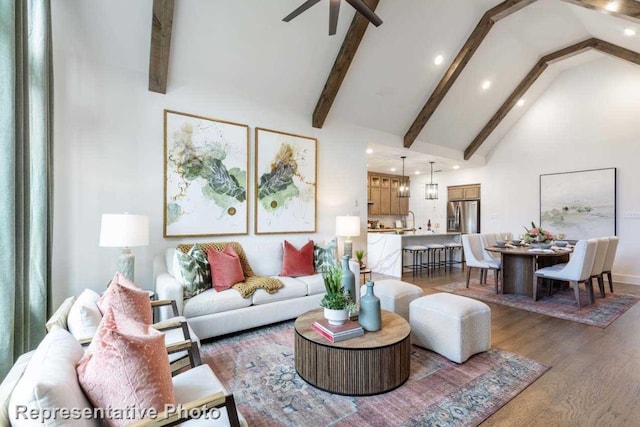 living room featuring ceiling fan, sink, beamed ceiling, and dark hardwood / wood-style floors