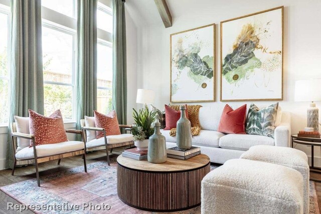 interior space with wood-type flooring, lofted ceiling with beams, and a wealth of natural light