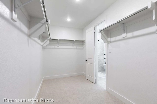 walk in closet featuring light carpet