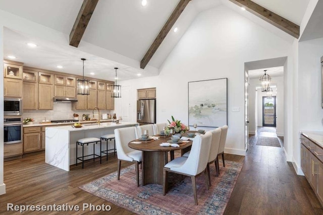 dining space with dark hardwood / wood-style flooring, beamed ceiling, and sink