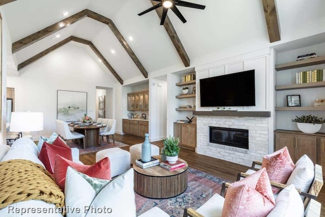 living room with beamed ceiling, dark hardwood / wood-style floors, built in features, and a brick fireplace