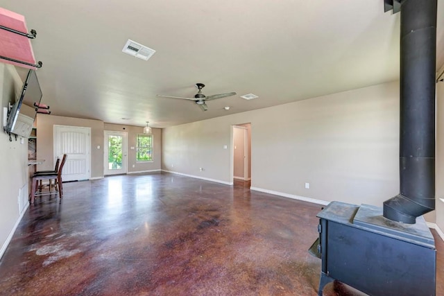 living room featuring a wood stove and ceiling fan