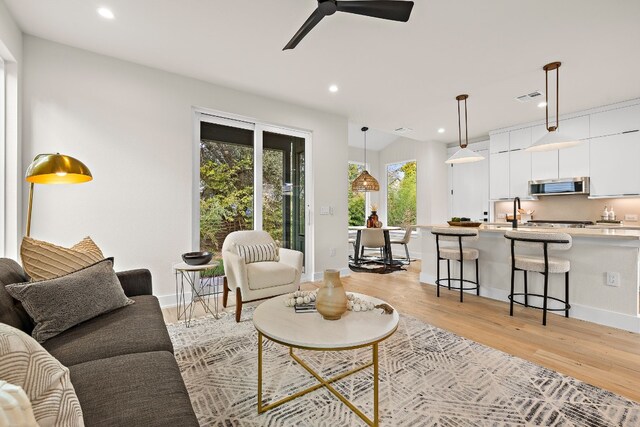 living room featuring ceiling fan and light hardwood / wood-style flooring