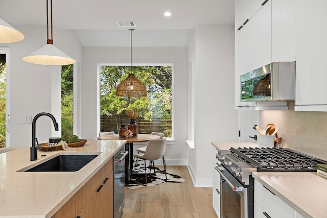 kitchen with pendant lighting, white cabinets, and stainless steel appliances