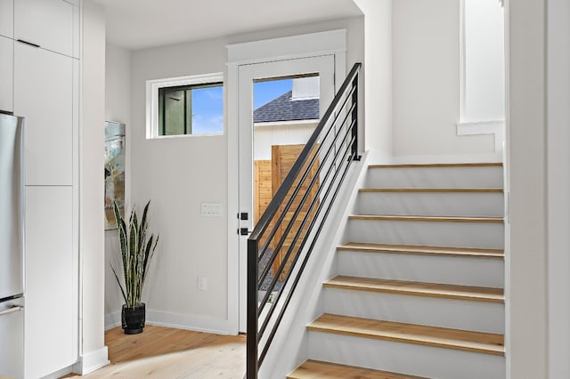 stairway with wood finished floors and baseboards