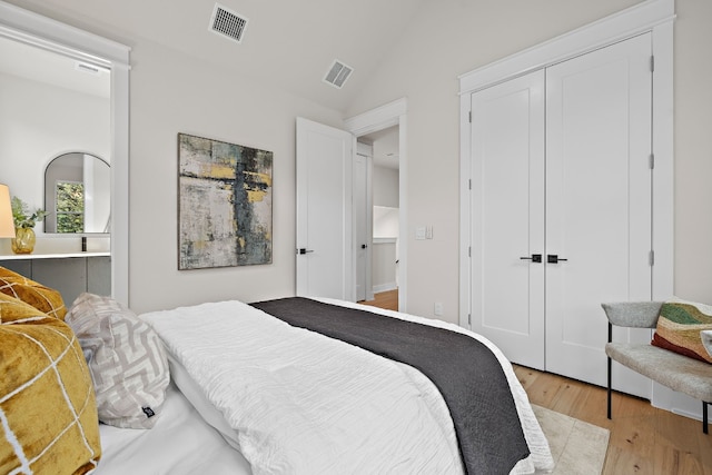 bedroom with light hardwood / wood-style flooring, a closet, and lofted ceiling