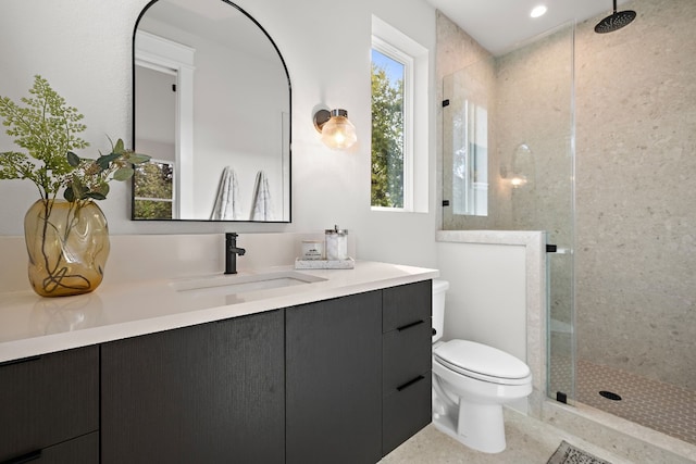 bathroom featuring a stall shower, vanity, and toilet