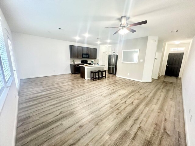 living room with light hardwood / wood-style floors and ceiling fan