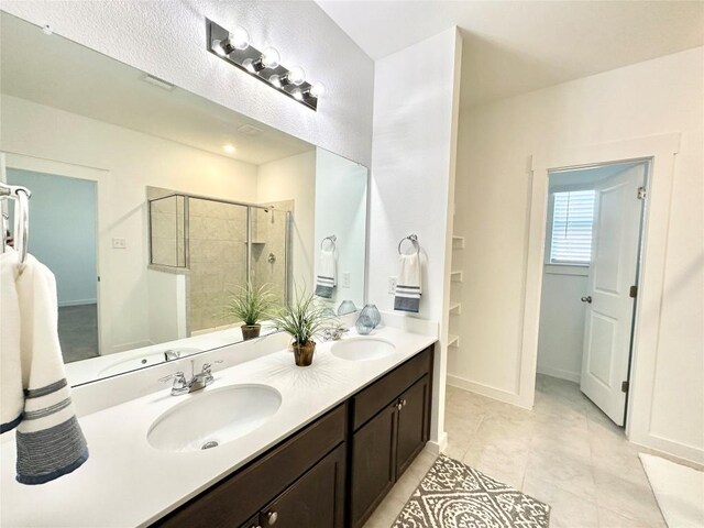 bathroom with tile patterned floors, vanity, and an enclosed shower