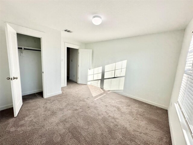 unfurnished bedroom with carpet flooring and a closet