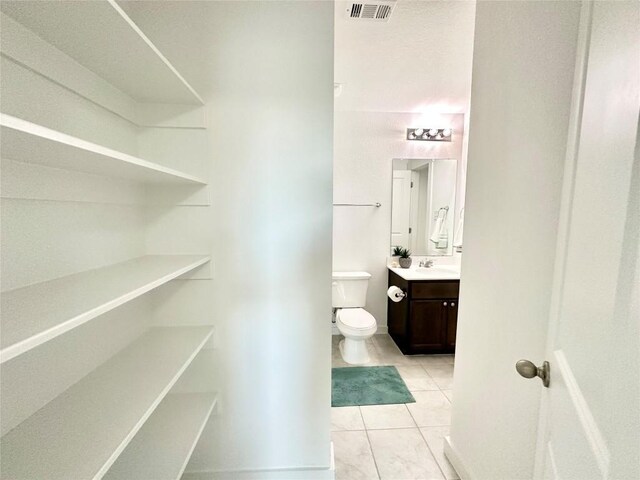 bathroom with vanity, toilet, and tile patterned flooring