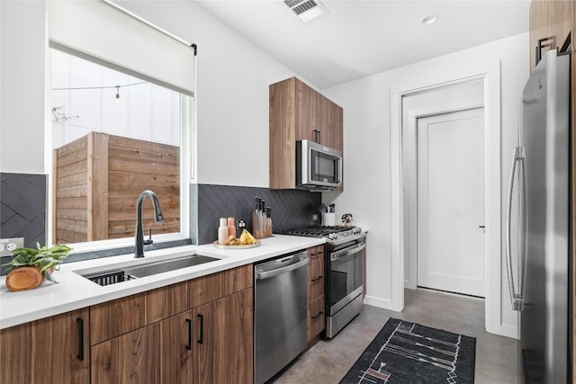 kitchen with tasteful backsplash, sink, and appliances with stainless steel finishes