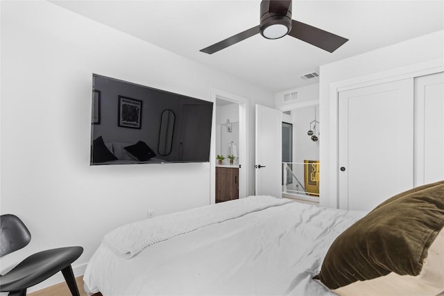 bedroom featuring ensuite bath, ceiling fan, a closet, and hardwood / wood-style floors