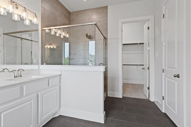 full bathroom with vanity, a spacious closet, and a stall shower