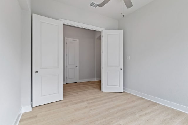 unfurnished bedroom featuring light wood-style floors, visible vents, a ceiling fan, and baseboards