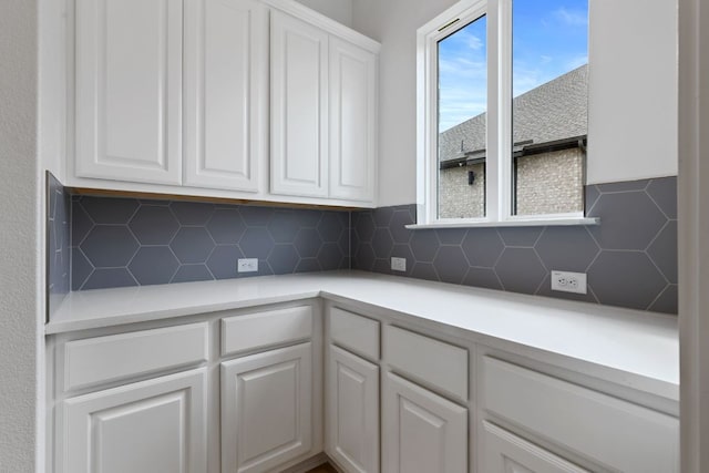 kitchen with white cabinetry, tasteful backsplash, and light countertops