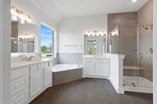 bathroom featuring two vanities, a stall shower, and a sink
