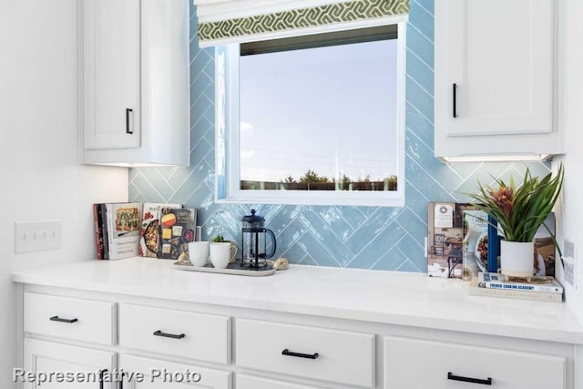 bar with white cabinetry and backsplash