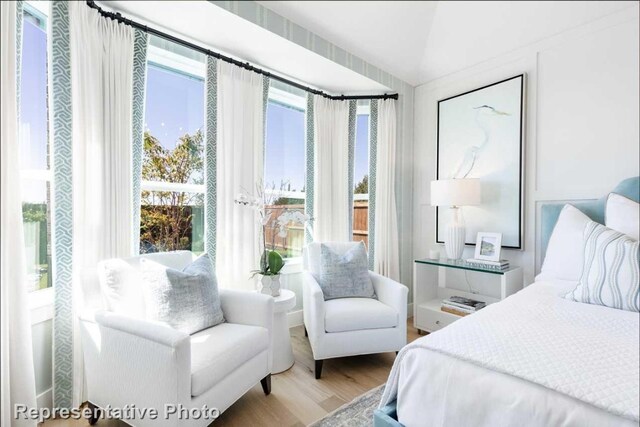 bedroom with light hardwood / wood-style floors and lofted ceiling