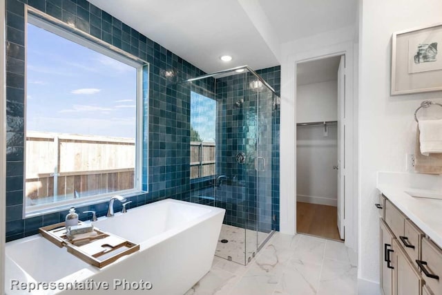 bathroom featuring vanity, separate shower and tub, and a wealth of natural light