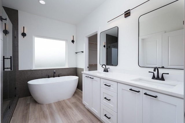 bathroom featuring hardwood / wood-style floors, vanity, separate shower and tub, and tile walls