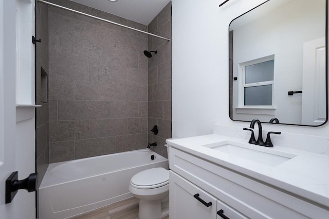 full bathroom with tiled shower / bath combo, toilet, wood-type flooring, and vanity