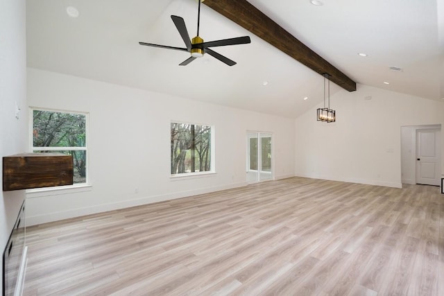 unfurnished living room with beamed ceiling, plenty of natural light, and light hardwood / wood-style floors