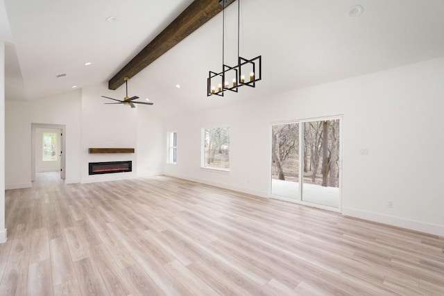 unfurnished living room with beamed ceiling, ceiling fan with notable chandelier, and light hardwood / wood-style flooring