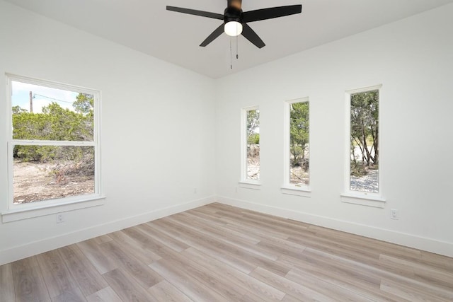 spare room featuring ceiling fan, plenty of natural light, and light wood-type flooring