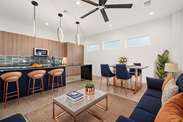 living room featuring ceiling fan and sink