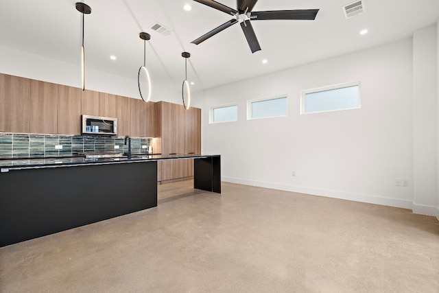 kitchen featuring pendant lighting, ceiling fan, and tasteful backsplash