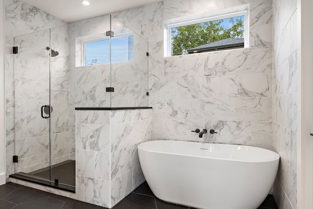 bathroom featuring tile patterned flooring, separate shower and tub, and tile walls