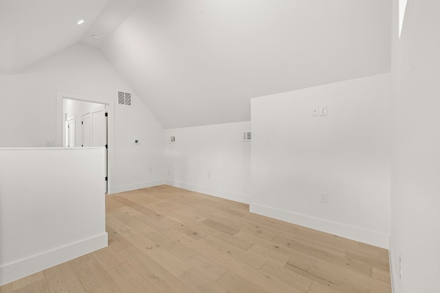 additional living space featuring light wood-type flooring and lofted ceiling