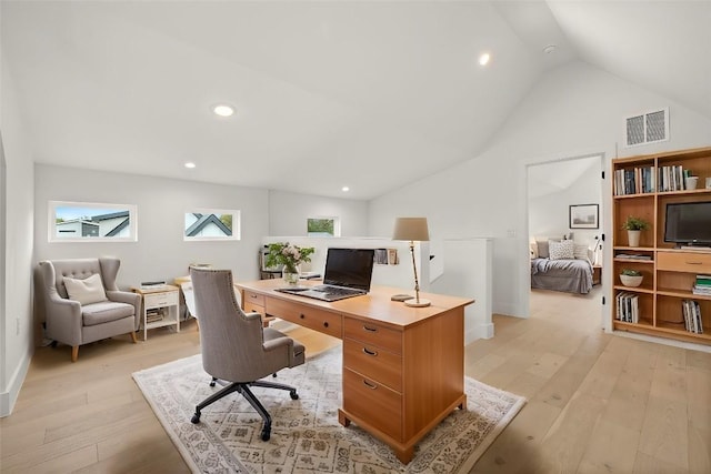 office with light wood-type flooring and lofted ceiling