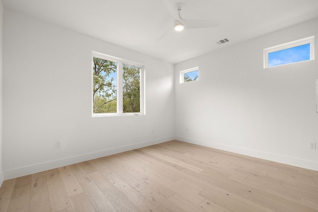 empty room with ceiling fan and light hardwood / wood-style flooring