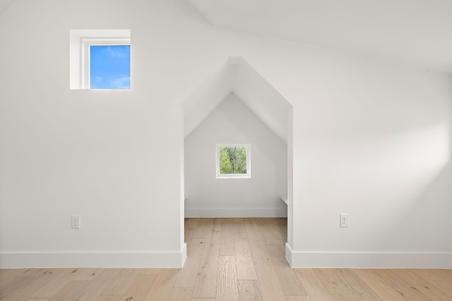 additional living space featuring light hardwood / wood-style floors and vaulted ceiling