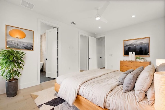 bedroom with ceiling fan, connected bathroom, and light hardwood / wood-style flooring