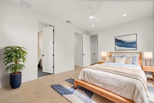 bedroom featuring ceiling fan, light wood-type flooring, and connected bathroom